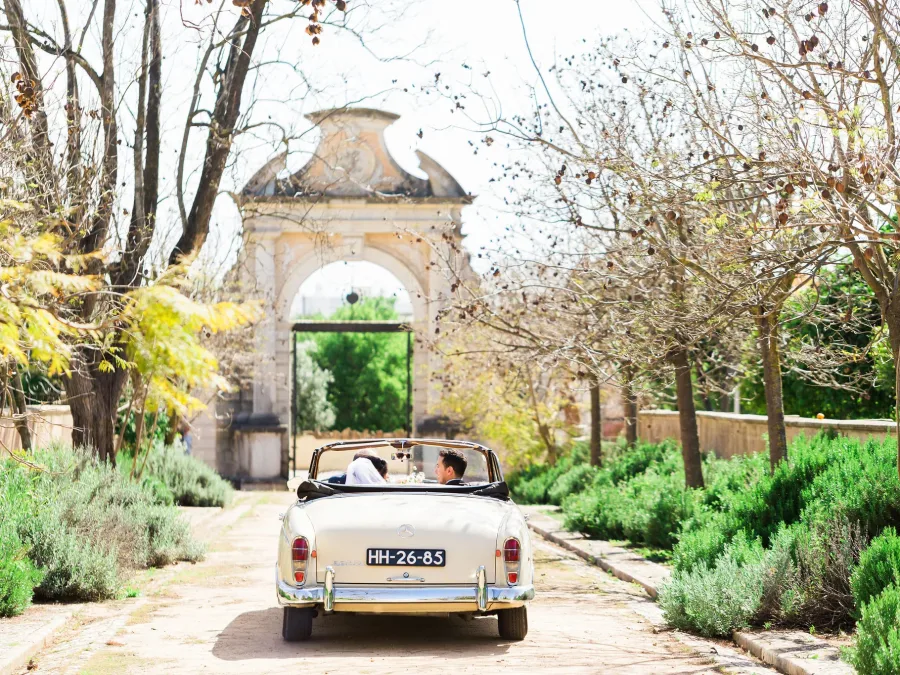 bride and groom on vintage car at estoi palace