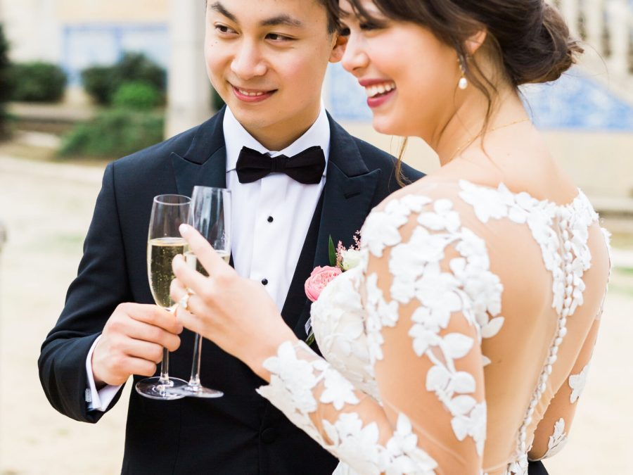 Bride and groom drinking champagne during elegant palace wedding in Portugal